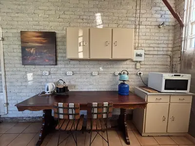 a kitchen with a wooden table with a microwave at Green Thumb Farm Stay in Ermelo