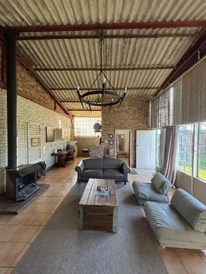 a large living room with a couch and a table at Green Thumb Farm Stay in Ermelo