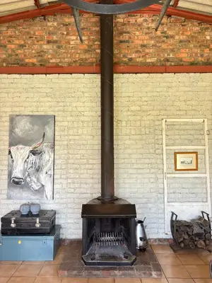 a fireplace in a brick wall with a picture of a cow at Green Thumb Farm Stay in Ermelo
