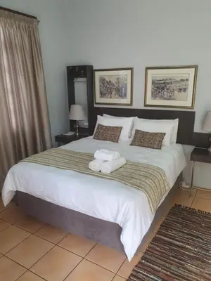 a bedroom with a large bed with towels on it at Purdy's Place in Louis Trichardt
