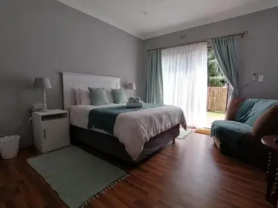 a bedroom with a bed and a couch and a window at Purdy's Place in Louis Trichardt