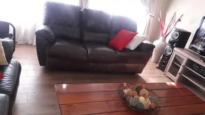 a living room with a leather couch and a bowl of fruit at Tehilah in Sabie