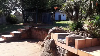 a stone retaining wall with stairs and a gate at Tehilah in Sabie