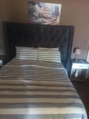 a large bed with a black headboard and pillows at Tehilah in Sabie