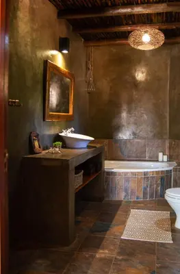 a bathroom with a tub and a sink and a toilet at Lamai Safari Lodge in Balule Game Reserve