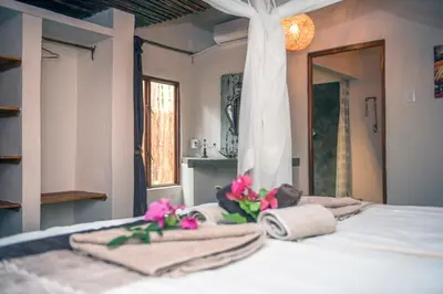 a bedroom with a bed with towels and flowers on it at Lamai Safari Lodge in Balule Game Reserve