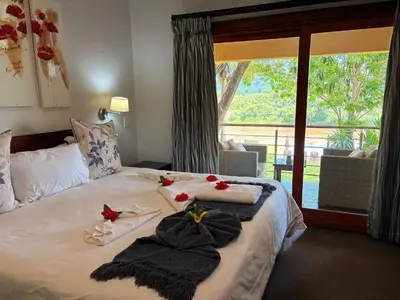 a bedroom with a bed with towels and flowers on it at Rio Vista Lodge in Malelane