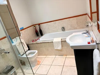 a bathroom with a tub and a toilet and a sink at Rio Vista Lodge in Malelane