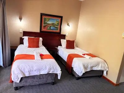a room with two beds in a hotel room at Rio Vista Lodge in Malelane