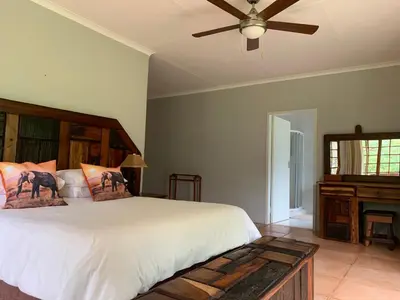 a bedroom with a bed and a ceiling fan at Kransberg Country Lodge Guest Farm in Thabazimbi