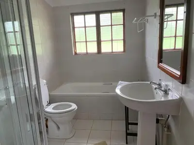 a bathroom with a sink and a toilet and a tub at Kransberg Country Lodge Guest Farm in Thabazimbi