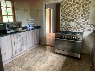 a kitchen with a stove and a microwave at Kransberg Country Lodge Guest Farm in Thabazimbi