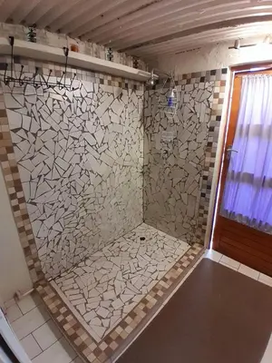 a bathroom with a shower with a tiled wall at Yacht View Lodge in Schoemansville