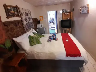 a bedroom with a bed with two slippers on it at Yacht View Lodge in Schoemansville