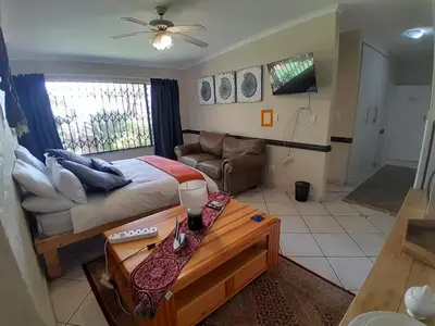 a bedroom with a bed and a living room at Yacht View Lodge in Schoemansville