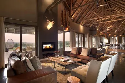 a living room with leather furniture and a fireplace at MHONDORO SAFARI LODGE & VILLA in Welgevonden Game Reserve