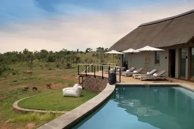 a house with a swimming pool next to a building at MHONDORO SAFARI LODGE & VILLA in Welgevonden Game Reserve