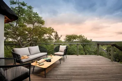a deck with two couches and a coffee table at MHONDORO SAFARI LODGE & VILLA in Welgevonden Game Reserve