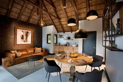 a living room with a table and chairs and a couch at MHONDORO SAFARI LODGE & VILLA in Welgevonden Game Reserve