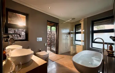 a bathroom with a large tub and a sink at MHONDORO SAFARI LODGE & VILLA in Welgevonden Game Reserve