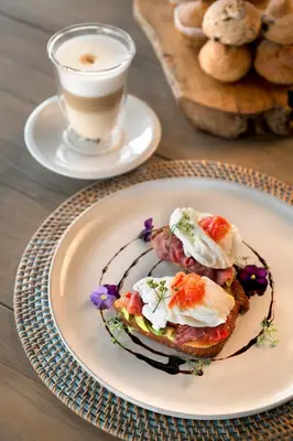 a plate of food on a table with a cup of coffee at MHONDORO SAFARI LODGE & VILLA in Welgevonden Game Reserve