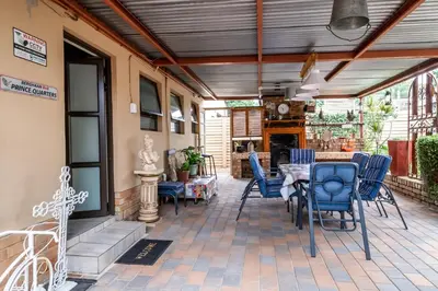 a patio with blue chairs and a table at Berghaan Pretoria in Pretoria