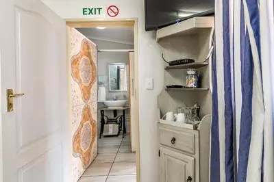 a hallway with a bathroom with a sink and a door at Berghaan Pretoria in Pretoria