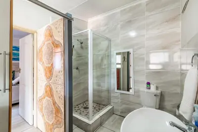 a bathroom with a shower and a toilet at Berghaan Pretoria in Pretoria