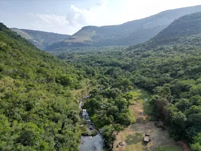 an aerial view of a river in a valley with mountains at Rocky Drift Private Nature Reserve in Waterval Boven