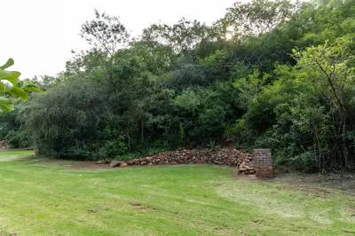 a pile of rocks in a field next to trees at Rocky Drift Private Nature Reserve in Waterval Boven
