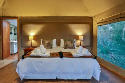 a bedroom with a large bed in a tent at Tangala Safari Camp in Thornybush Game Reserve