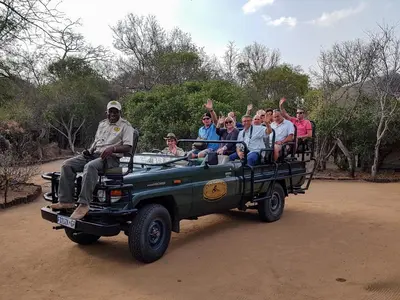 a group of people riding in the back of a truck at Tangala Safari Camp in Thornybush Game Reserve