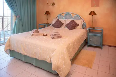 a bedroom with a bed with two towels on it at Haus Kopatsch in Hazyview