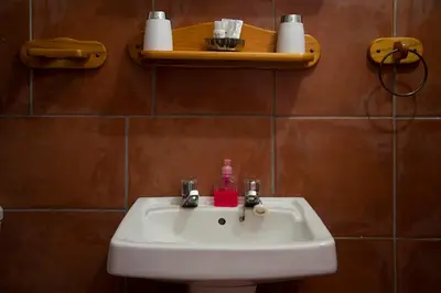 a bathroom sink with a soap dispenser on it at Haus Kopatsch in Hazyview