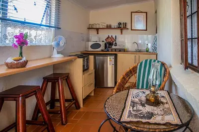 a kitchen with a table and some chairs and a counter at Haus Kopatsch in Hazyview