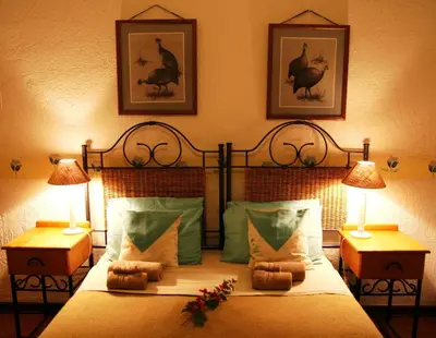 a bedroom with a large bed with two lamps on it at Haus Kopatsch in Hazyview