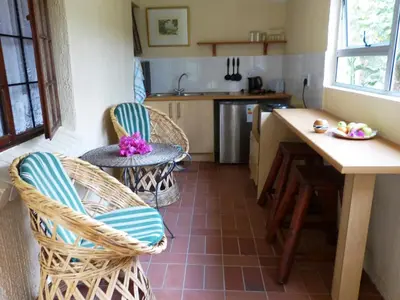 a kitchen with wicker chairs and a table at Haus Kopatsch in Hazyview