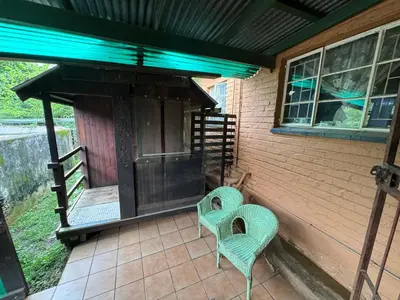 two chairs sitting on the porch of a house at Sabie Gypsy's Backpackers in Sabie
