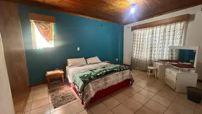 a bedroom with a bed and a blue wall at Sabie Gypsy's Backpackers in Sabie