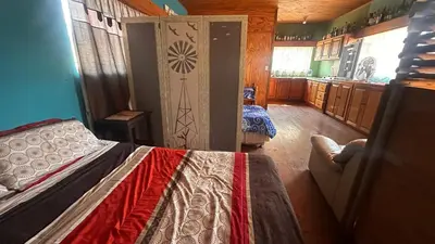 a bedroom with a bed and a room with a kitchen at Sabie Gypsy's Backpackers in Sabie