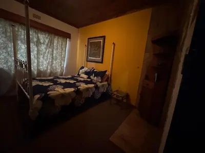 a bedroom with a bed and a window at Sabie Gypsy's Backpackers in Sabie