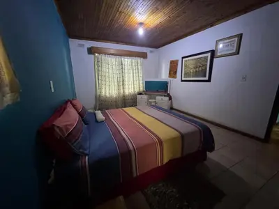 a bedroom with a bed in a room with a window at Sabie Gypsy's Backpackers in Sabie