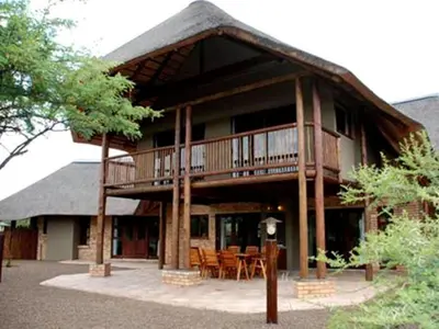 a large house with a deck with tables and chairs at Sondela Nature Reserve & Spa Makhato Lodges in Bela-Bela