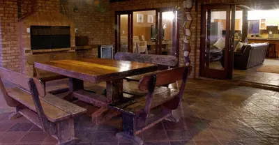 a wooden table and chairs in a room at Sondela Nature Reserve & Spa Makhato Lodges in Bela-Bela