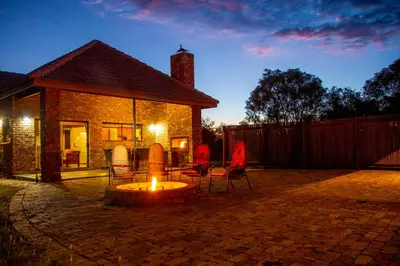 a patio with chairs and a fire pit in front of a house at Sondela Nature Reserve & Spa Chalets in Bela-Bela