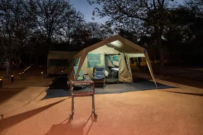 a tent with two chairs in front of it at Phalaborwa Safari Park, A Forever Resort in Phalaborwa