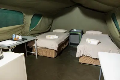 a tent with two beds and a table in it at Phalaborwa Safari Park, A Forever Resort in Phalaborwa