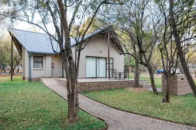 a small white house with a brick walkway at Phalaborwa Safari Park, A Forever Resort in Phalaborwa