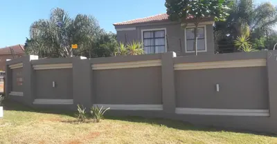 a privacy fence in front of a house at Lullaby Guesthouse in Tzaneen