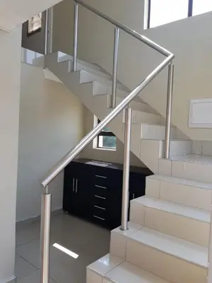 a staircase in a house with a glass railing at Lullaby Guesthouse in Tzaneen